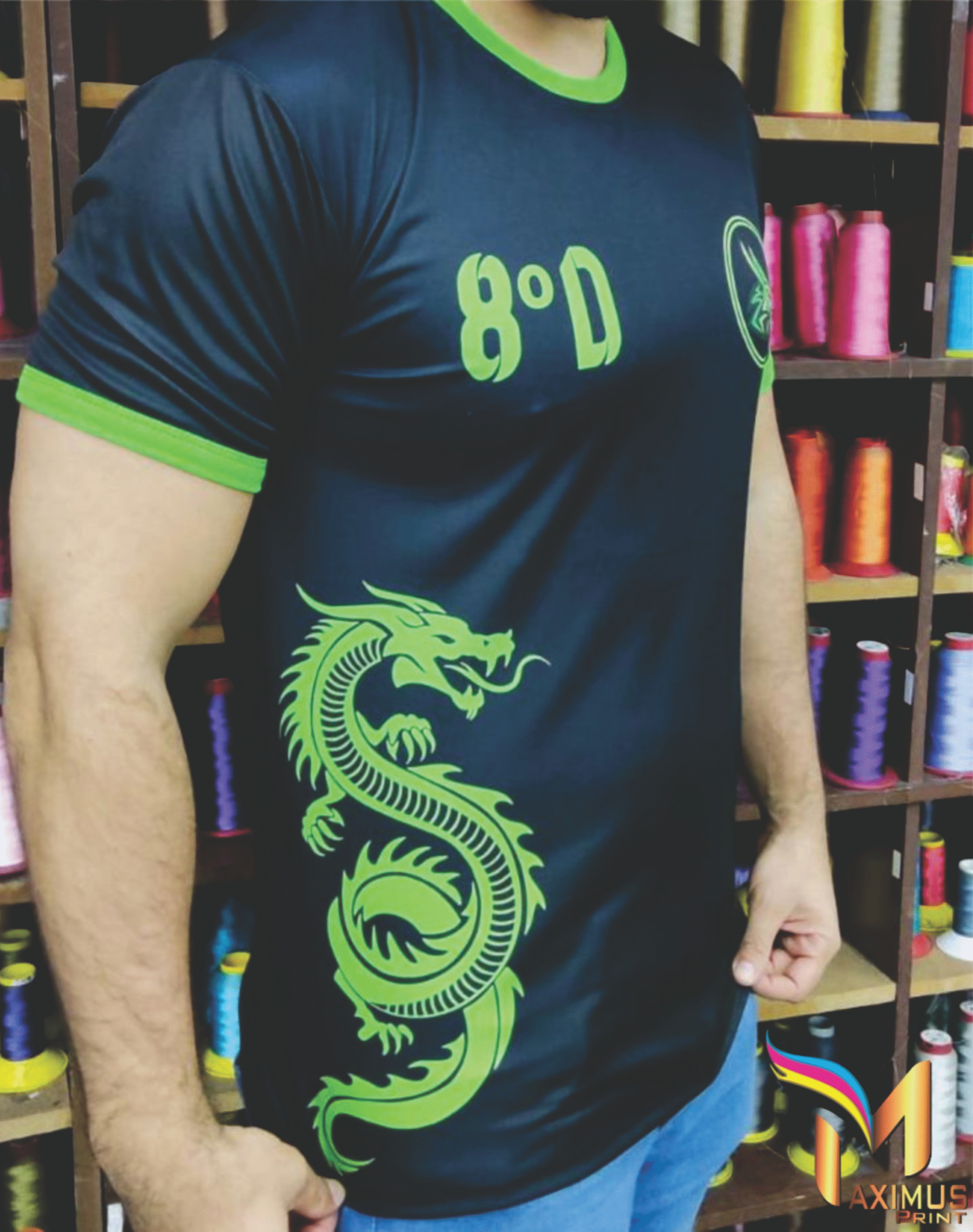 Detalhe lateral de camiseta preta personalizada com grande estampa de dragão em verde neon e identificação "8º D", produzida pela Maximus Print para uniformes escolares.