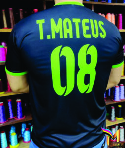 Detalhe lateral de camiseta preta personalizada com grande estampa de dragão em verde neon e identificação "8º D", produzida pela Maximus Print para uniformes escolares.